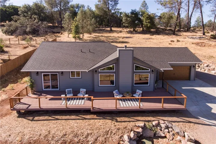 front of this home with a spacious deck and concrete patio in back.
