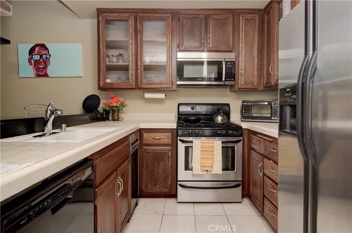 Stainless and black appliances in the kitchen- sleek! New faucet too!