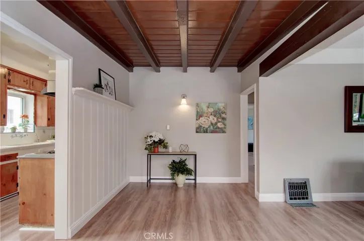 Entry has stylish beamed ceiling and wainscotting details.