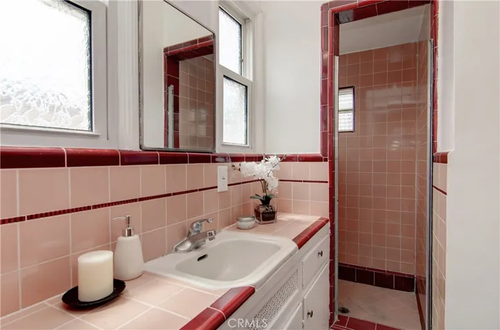 Master bath has period tile details and large shower.