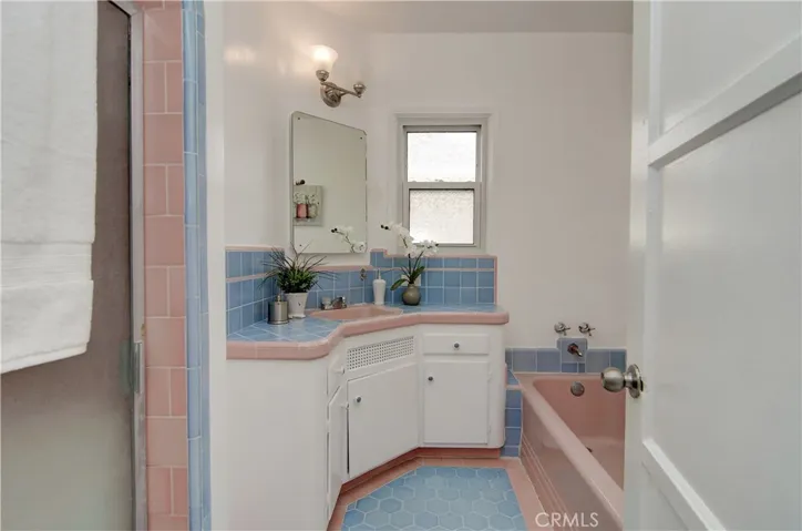 Hall bath has cool, original tile details, plus bathtub AND shower.