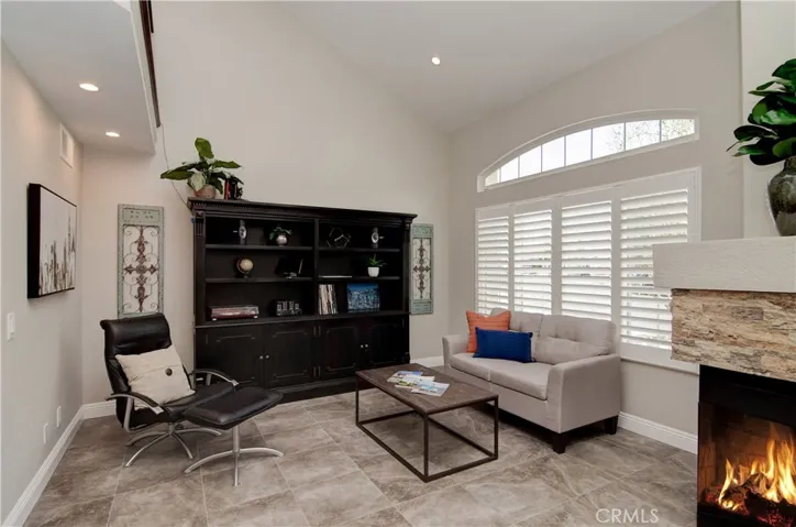Nice architectural details here with high ceilings, ledge stone fireplace and arched window.