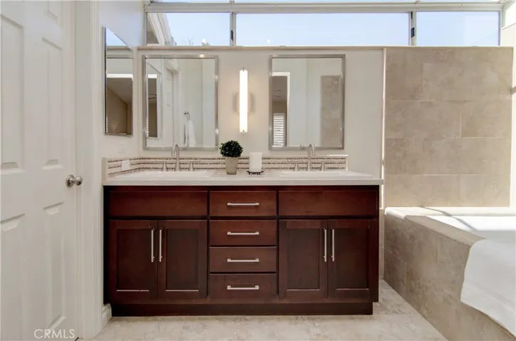 Stylish master bath has dual sink vanity with custom lighting and mirrors.