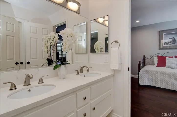 Gleaming Jack and Jill bath has dual vanities and separate shower area.