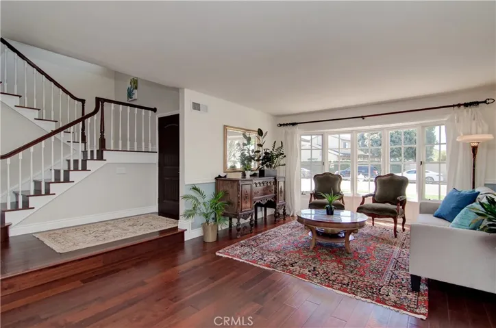 Living room boasts south facing bay window.  Custom stairway has wood treads.