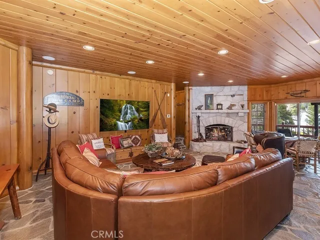 Downstairs family room with fireplace opens out to entertaining deck on the golf course. Stone floors with radiant heat.