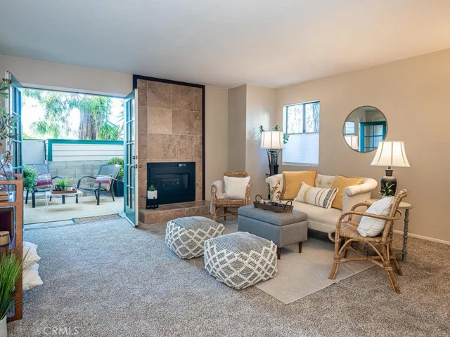 Newly carpeted living area with fireplace and double doors to rear patio.