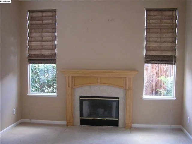 The right size room with focal point fireplace, window coverings and shutters and crown moulding.