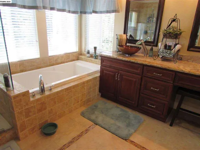 2nd vanity with vessel sink, waterfall fixture, soft close drawers, custom tile flooring, jetted tub