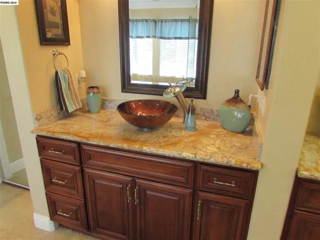 Vanity 1. Shows granite counters, Vessel sink with waterfall faucet, soft close drawers