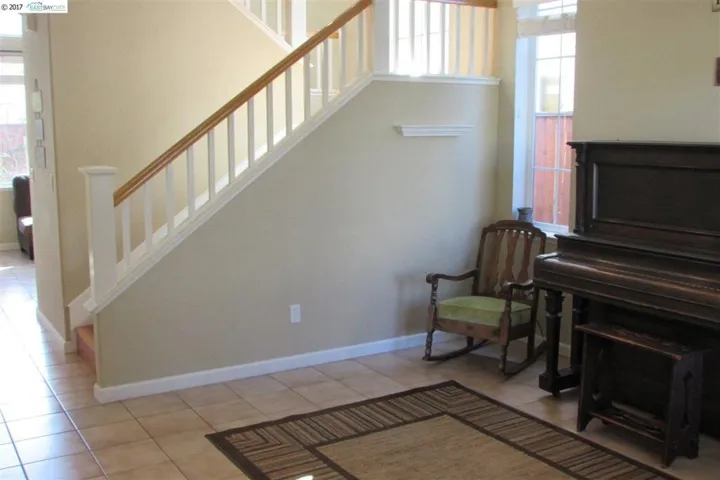 Living room has lots of natural lighting, tile floor and vaulted ceilings.
