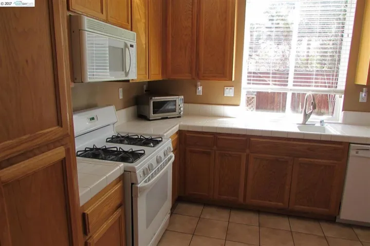 Showing pantry, microwave, gas stove top.