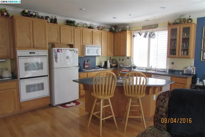 Beautiful kitchen has double ovens, a pantry to the left, hardwood floors and a great island!