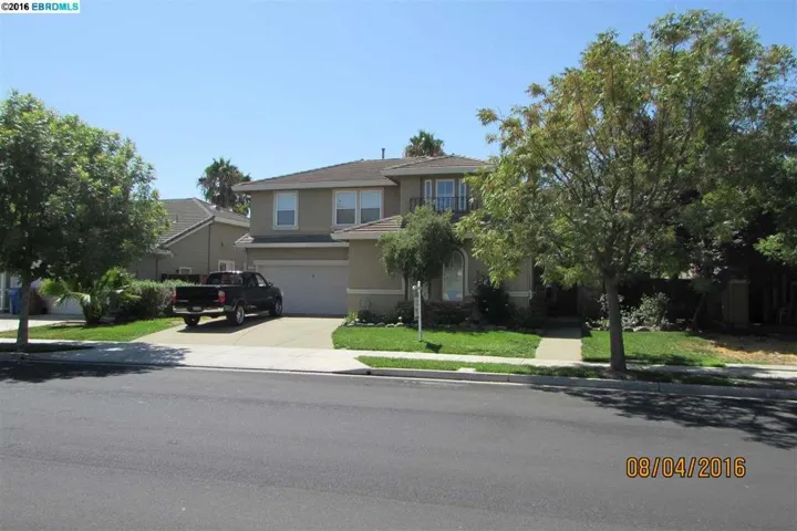Front showing green lawn, trees and wide driveway
