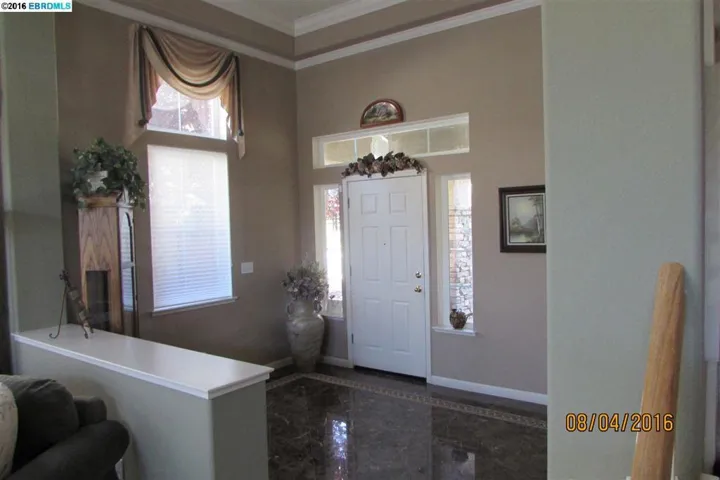 Spacious entry shows custom marble flooring, crown molding.