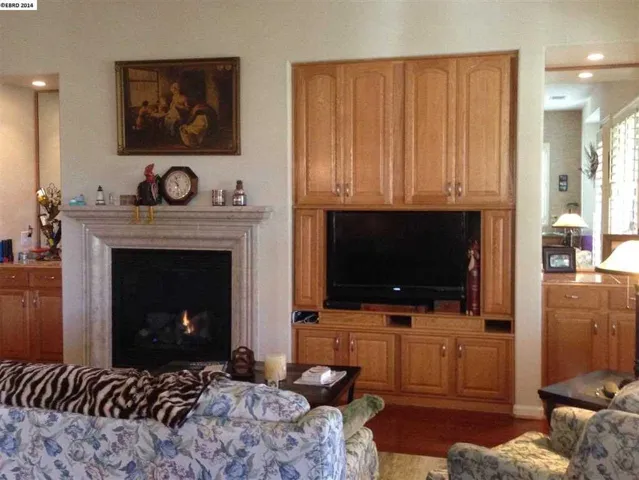 Cozy Fireplace, mirrored storage hutches & built in bar area make this the heart of the home.