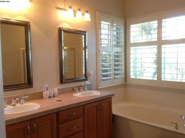 Two windows provide natural light for the double sink and vanity area.