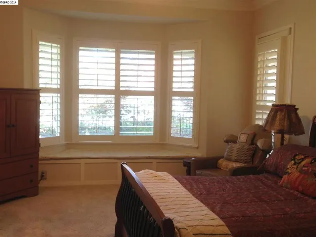 Large master easily accommodates your King sized bed.  Door leads to the covered backyard patio.