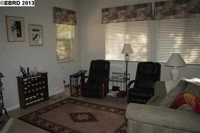 Family room / kitchen combo. Has beautiful window treatments, tile flooring, ceiling fan.