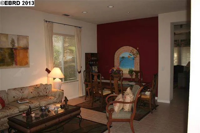 Lovely living / dining combo, spacious, tile flooring, custom paint accent on dining room wall.