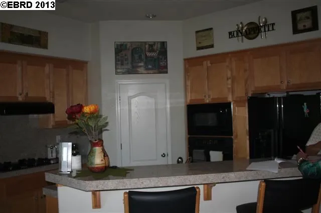 Kitchen has pantry, stone tile counters, breakfast counter