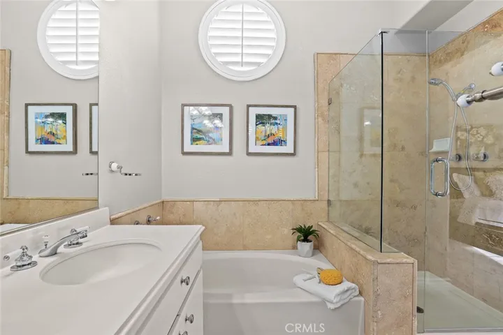 Remodeled master bathroom with double vanities, travertine shower, frameless shower door, brand new shower head and separate tub/shower stall.