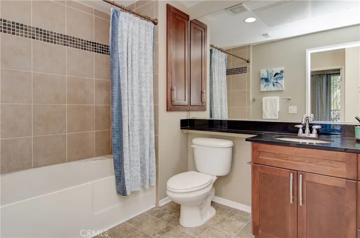 Huge bathroom has deep soaking tub with shower, storage and neutral decor.