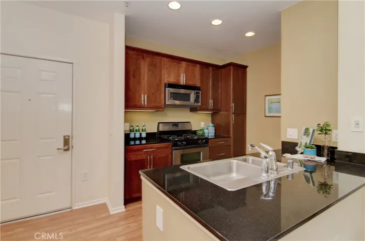Warm wood cabinetry, stone counters and stainless appliances enhance efficient kitchen.