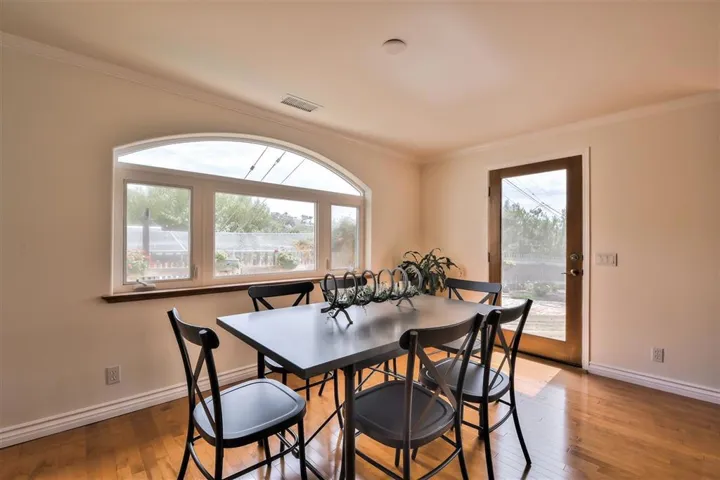 Light and bright Dining room area with nearby fireplace.. Arched window looks out to the Herb garden and French door goes onto the expansive deck for your outdoor entertaining.
