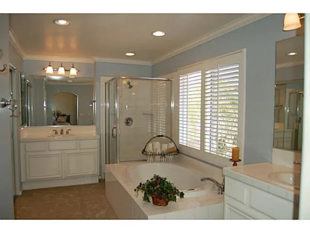 Master bathroom has dual vanities with soaking tub, shower and walk-in closet.