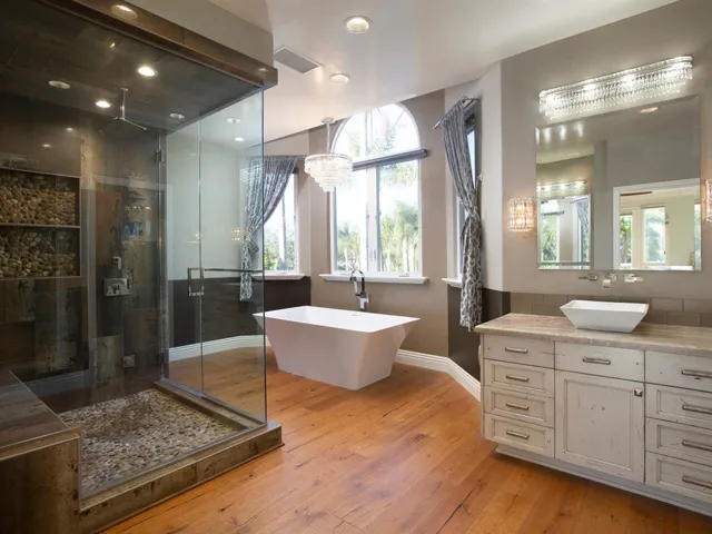 Master bath equipped with dual vanities, steam shower, Hydro Systems freestanding bathtub and a walk-in closet with custom built-ins