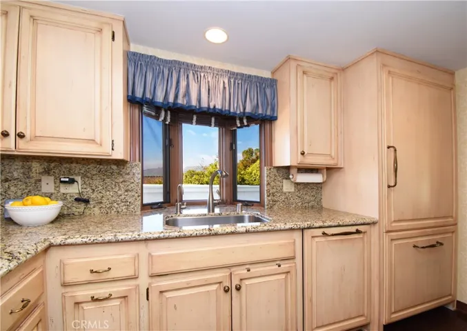 Remodeled kitchen with custom cabinetry and granite counters.