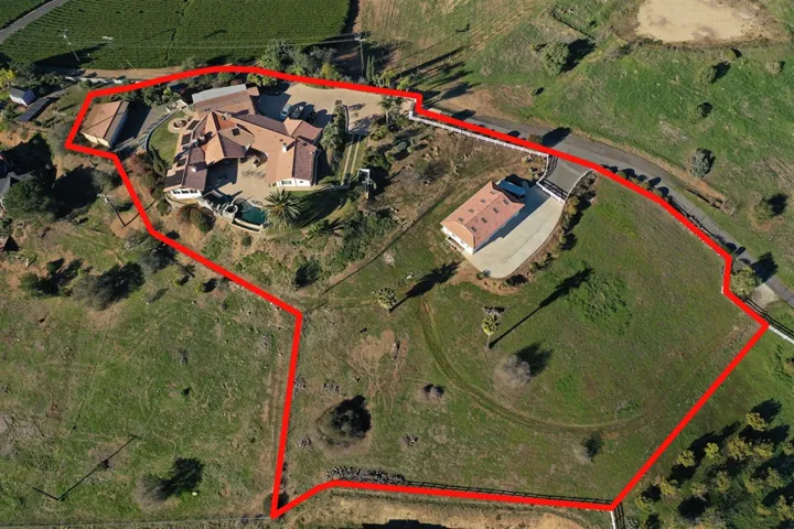 4 car detached garage to the left, main house in the center, shop toward the right and lower pasture/open area.