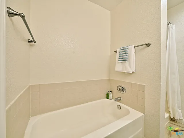 Separate tub with tile surround.