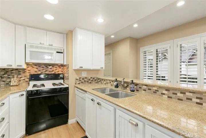 Kitchen includes stainless steel sink, newer kitchen cabinets, microwave, glass tile back-splash and recessed 
lighting.