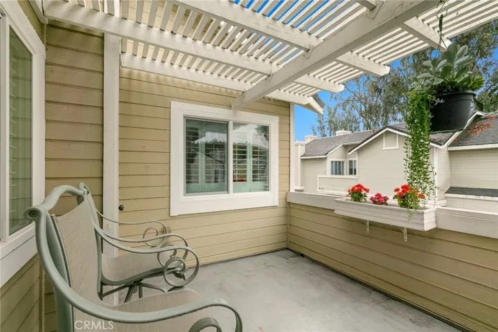 Private balcony has wood patio cover and is adjacent to living room and kitchen.  Balcony is located directly above 2 car garage.