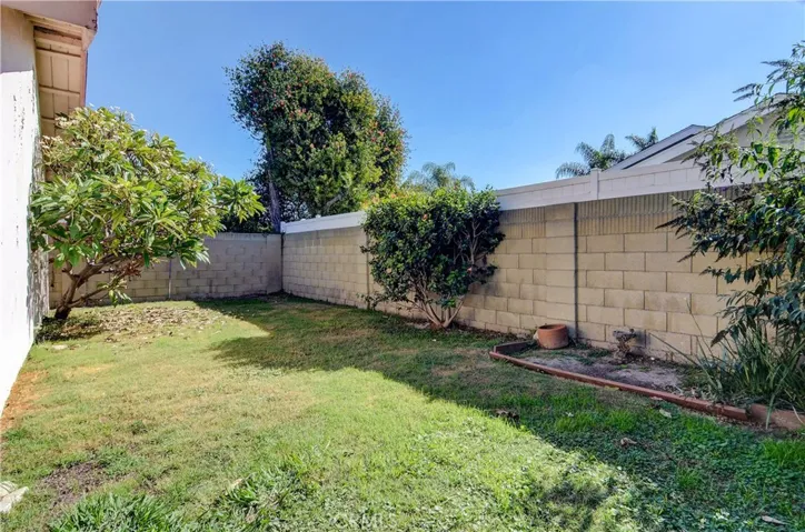 Back & side yards boast sturdy block wall fencing.