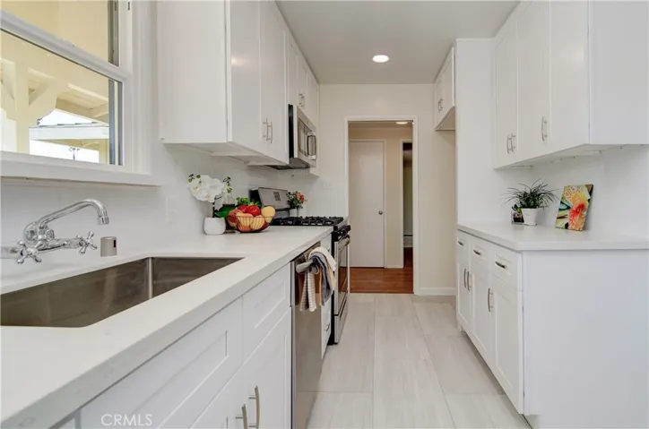 Gorgeous, completely remodeled kitchen has loads of white cabinets, quartz counters, LED lighting, LUX vinyl flooring and what every cook enjoys...a window at the sink!