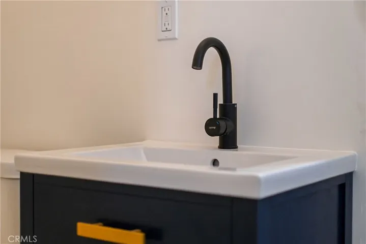 A stylish blue 24" vanity with rubbed bronze fixtures