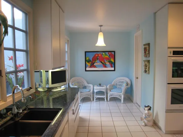 The kitchen offers granite counter tops, amble cabinetry, sitting area and sliders to the patio