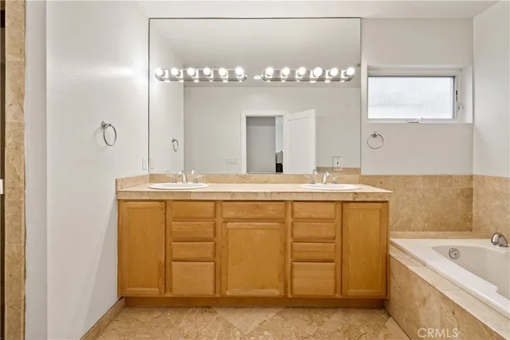 En-suite primary bathroom with double vanity and separate jacuzzi-style tub and shower