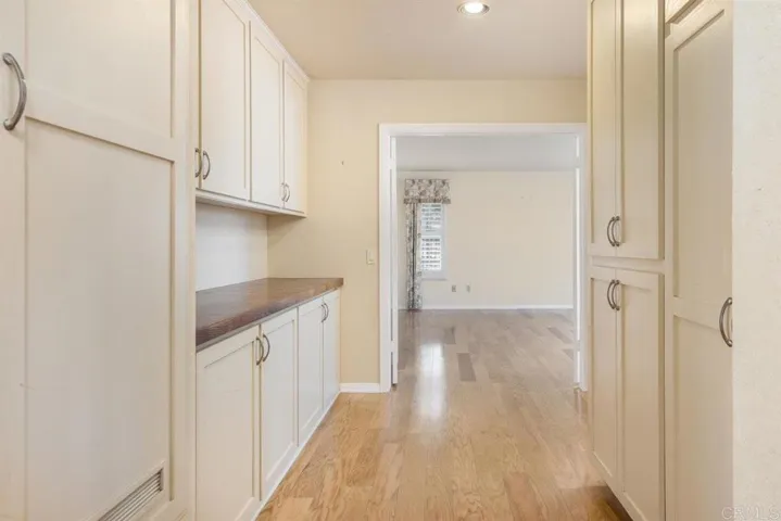 Wide hallway with storage, looking directly into master bedroom w/double door entry.