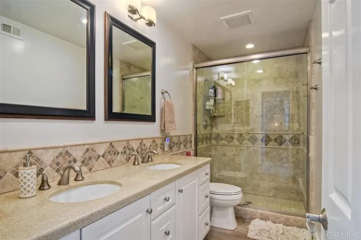 Secondary bathroom with dual sinks.