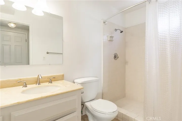 main level bathroom with newly updated fixtures, lighting, and mirrors