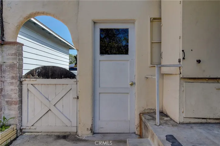 We are not lacking in Architectural Details...cute arch and brick pilaster over gate to front yard. Door right off back porch to garage is super convenient.