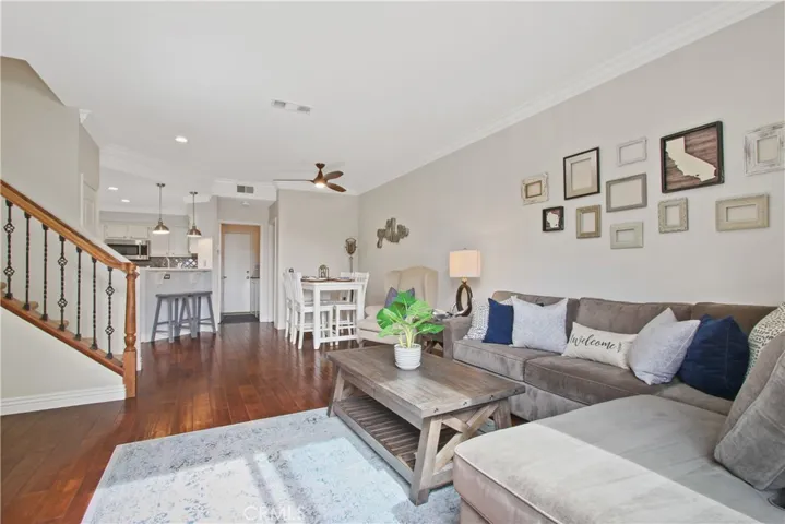 Here is a view looking from the family room back towards the kitchen & dining area. Also note the completely updating stairway banister with rich stained wood to match the floors and designer wrought iron railing!
