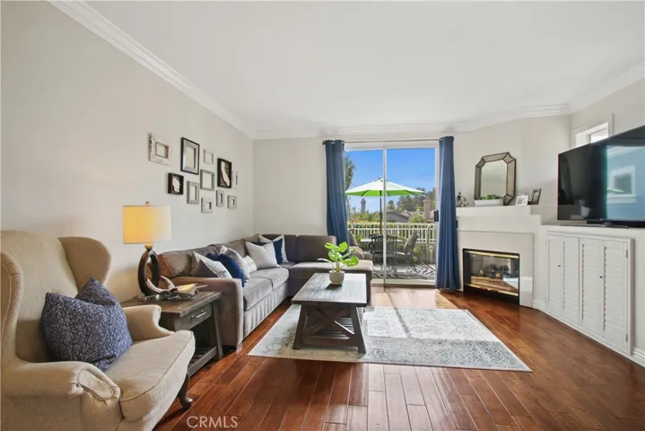 The family room showcases beautiful engineered wood flooring, crown moulding and blue sky views from the rear patio sliding door. Plenty of storage under the TV area for all of your electronics and media.