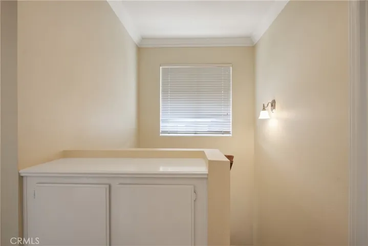 A large window and linen storage / countertop at the top of the stairs. Crown moulding too!