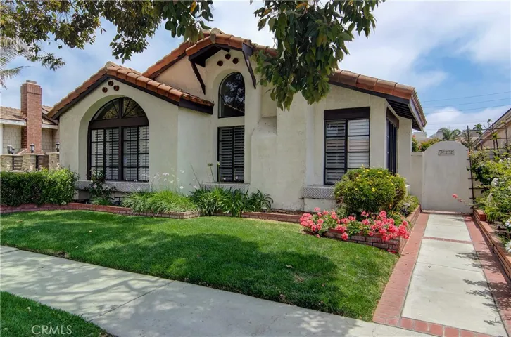 Classic California details are framed by lush landscape and raised planters.