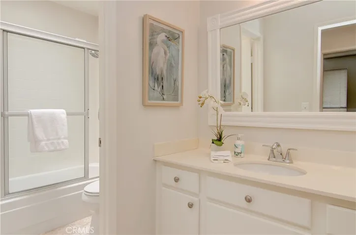 Sparkling hall bath has separate vanity area and skylite.